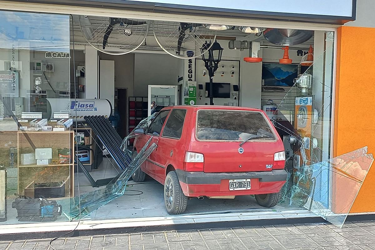 El auto incrustado en la vidriera del local.