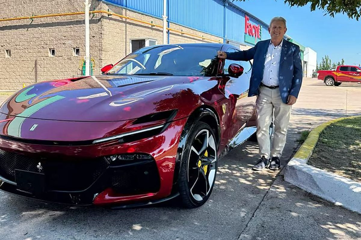 El ex trabajador de la represa posando con su Ferrari.